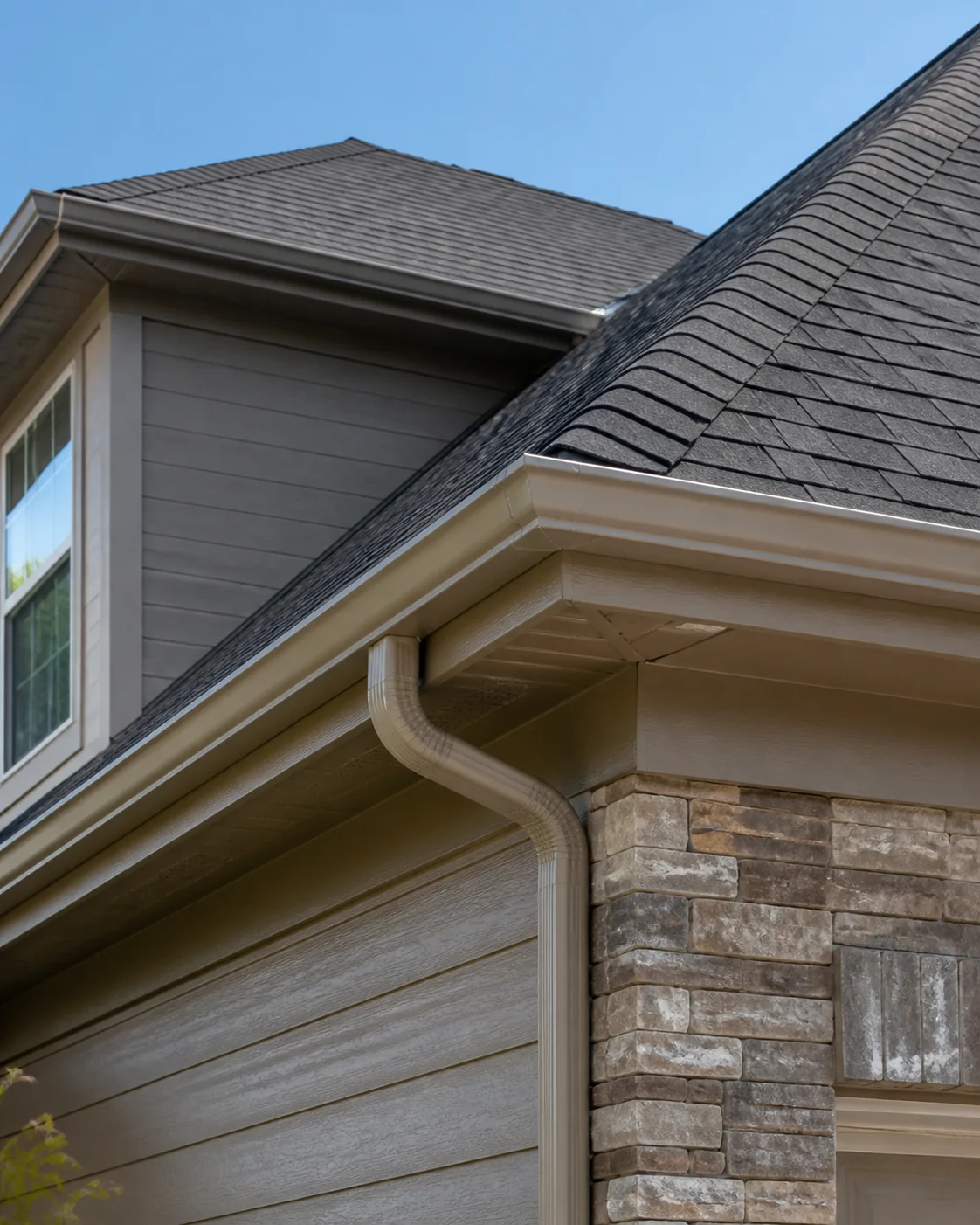 Finished residential roofline with shingles, flashing, fascia, and gutters
